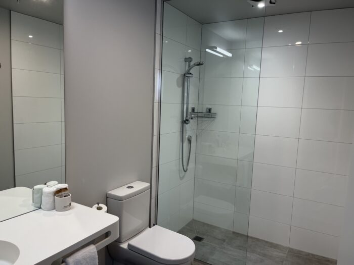 ガラスパーテーションでシャワーとトイレを仕切った3点ユニットバスの一体型リフォーム例