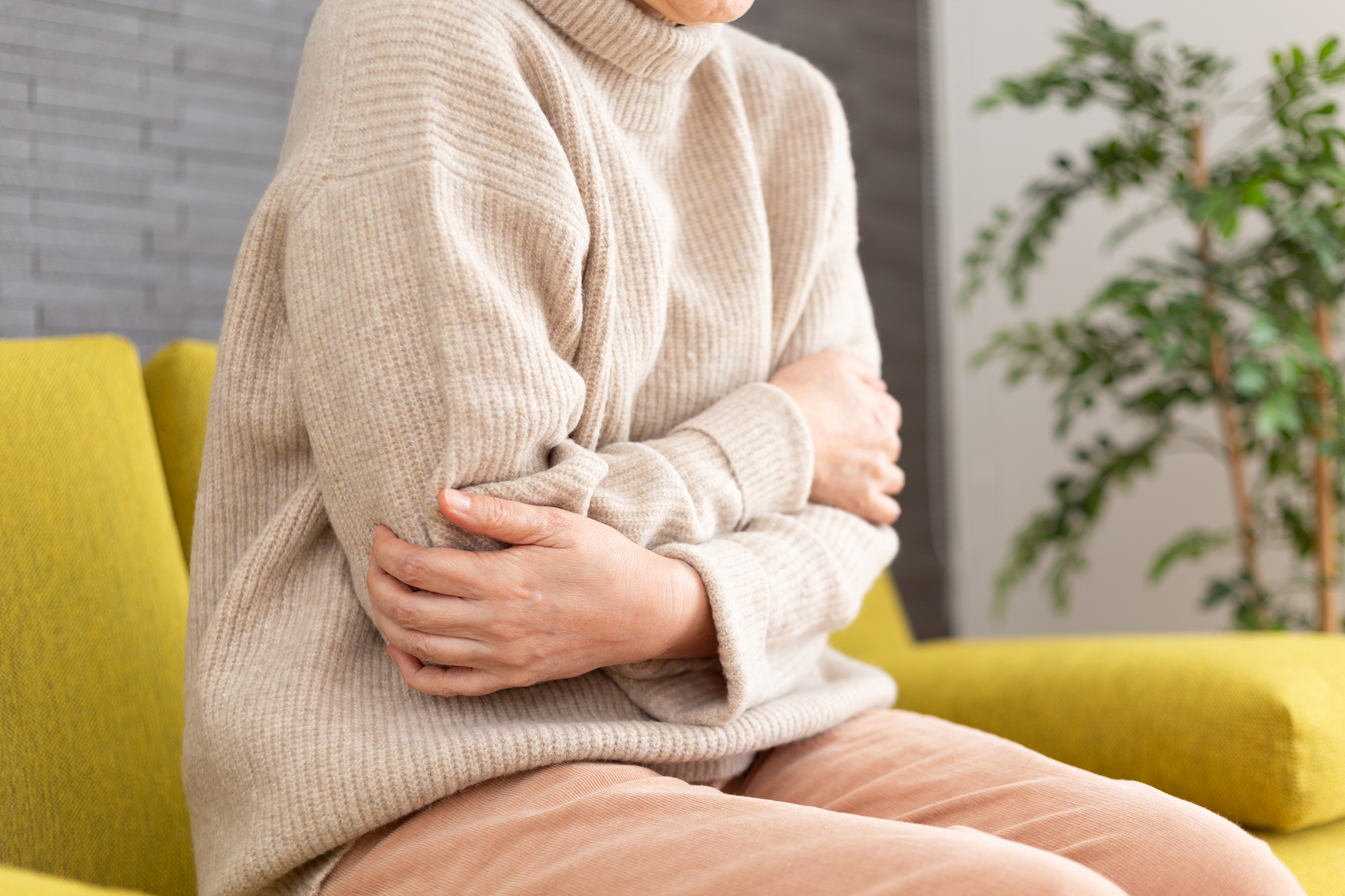 冬の部屋で寒がる女性