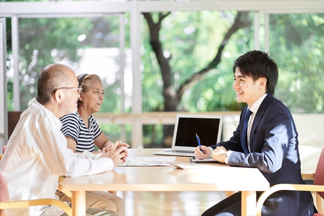 家族信託と成年後見制度の違いについて専門家に相談し笑顔を見せる高齢夫婦