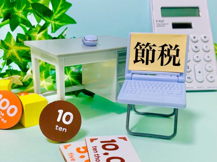 中古アパートの建物や設備を分けて節税効果を高めるイメージの「節税」メモとパソコン